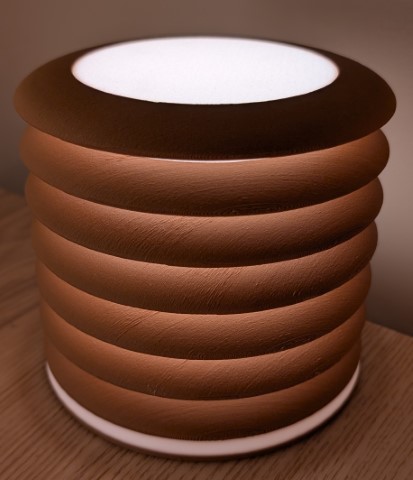 Side-lit 3D-printed lamp with subtle ring shadows and glowing circular base and top