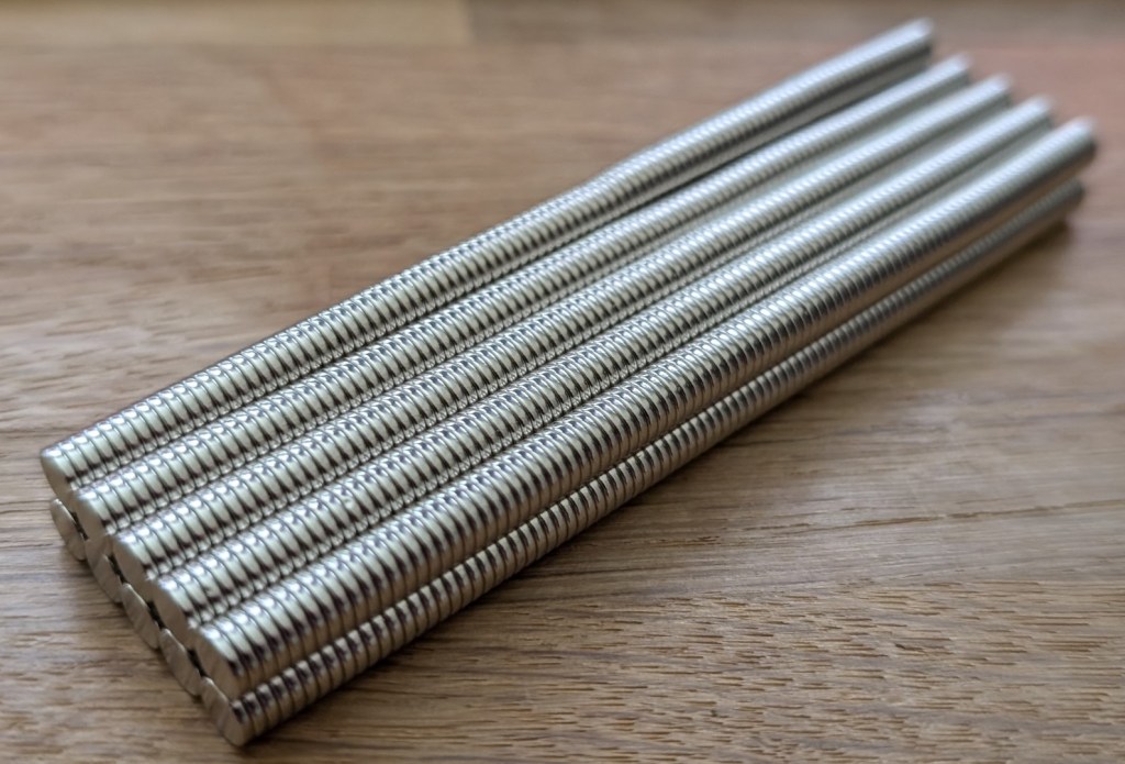 Close-up of 1000 tiny neodymium magnets stacked into tidy silver columns. Looks like “mildly threatening spaghetti” but is apparently strong enough to hold up an entire fridge pattern.