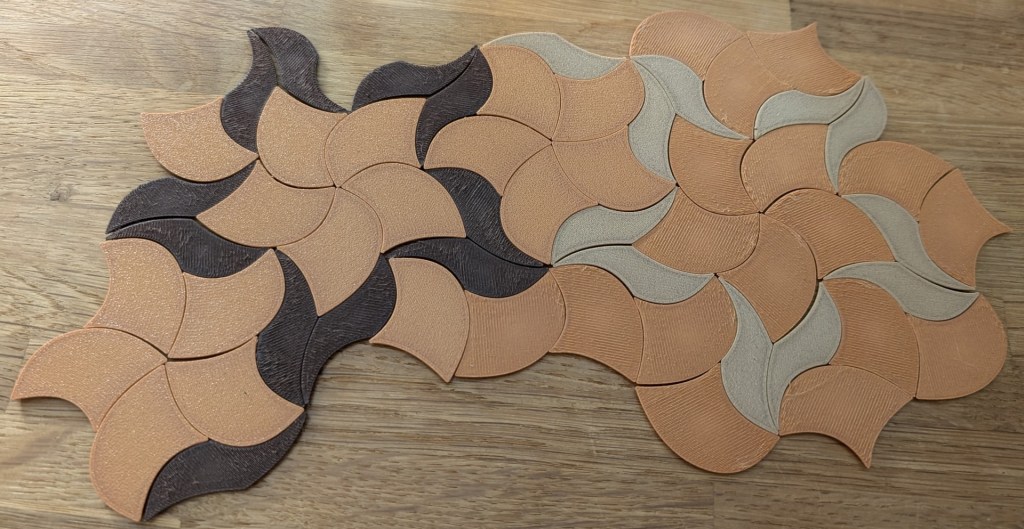 Close-up of 3D-printed Penrose P3 parabolic tiles arranged in a wavy, organic pattern. It looks like starfish doing synchronized swimming, and yes, this is what my fridge chose to wear.