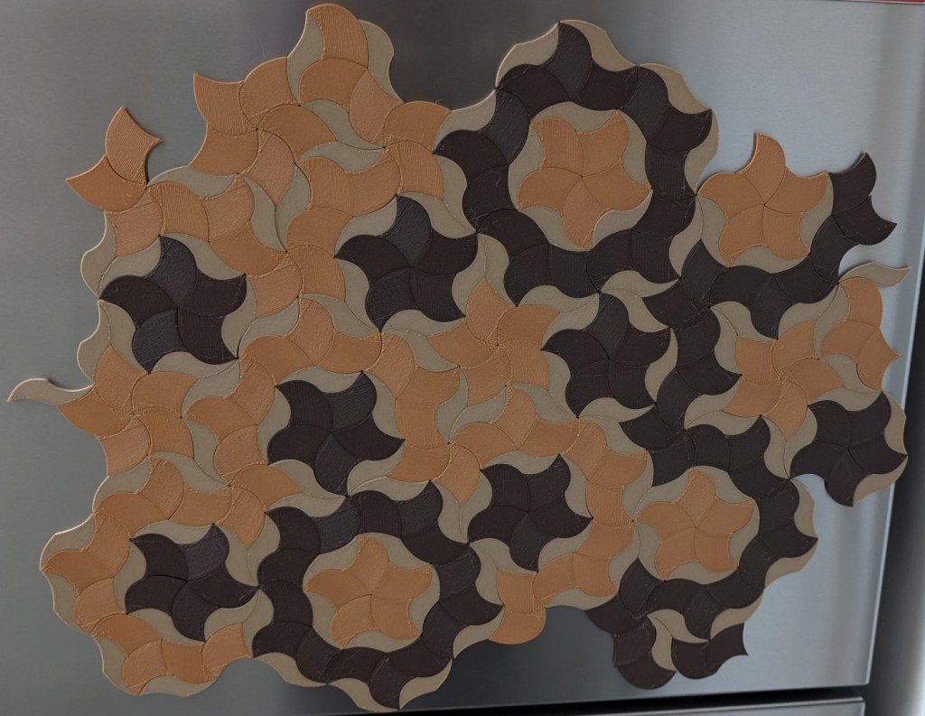 A second version of a Penrose tile fridge magnet pattern with more muted tones and better balance, though still visually chaotic like a geometry-themed buffet.
