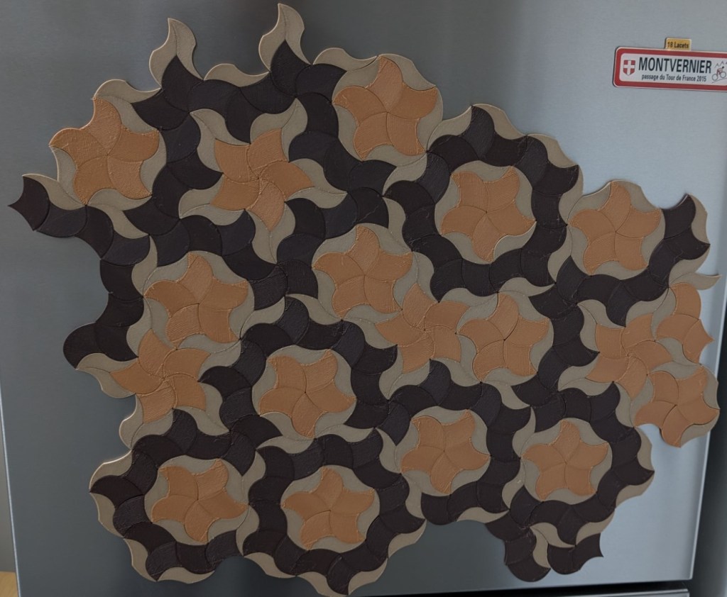 Third attempt at a Penrose tile fridge magnet pattern. The colours are more harmonious, but the layout looks slightly crooked, as if geometry itself had a pint too many.